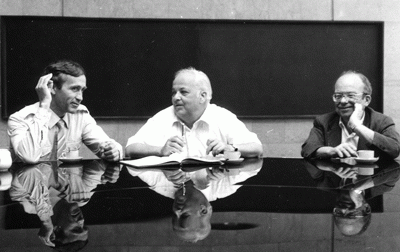 Sasha Skrinsky, Burton Richter and W. K. H. Panofsky seated at table in front of blackboard, Novosibirsk, August 1986